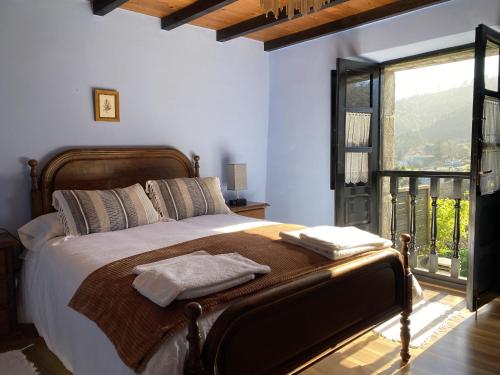ein Schlafzimmer mit einem Bett und einem großen Fenster in der Unterkunft Casa Las Hortensias 2 Pendueles in Llanes