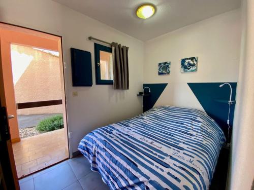 une petite chambre avec un lit et une fenêtre dans l'établissement Studio cabine rénové à 250m de l'étang de Thau avec jardinet et parking privé - FR-1-604-3, à Mèze