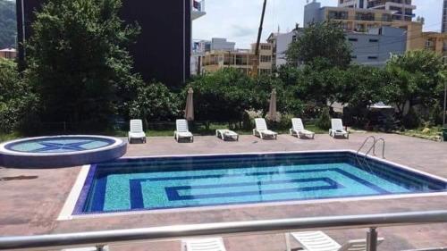 a large swimming pool with lounge chairs and avisorvisor at White Room in Gonio