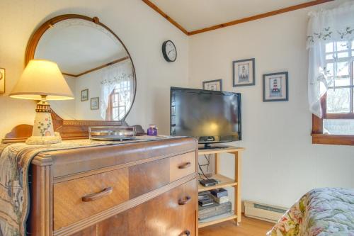 a bedroom with a dresser with a tv and a mirror at Less Than 1 Mi to Sea Street Beach Dennis Port Home! in Dennis Port