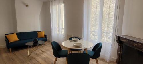 un salon avec un canapé bleu, une table et des chaises dans l'établissement Clichy Luxe Living, à Clichy