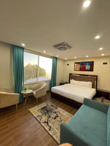 a bedroom with a large bed and a couch at Hamdan Hotel and Resort in Murree