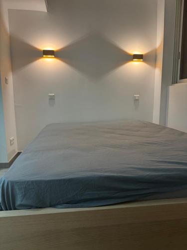 - une chambre avec un lit et deux lumières sur le mur dans l'établissement Bel appartement rénové 4 personnes proche plage et toutes commodités, à Six-Fours-les-Plages