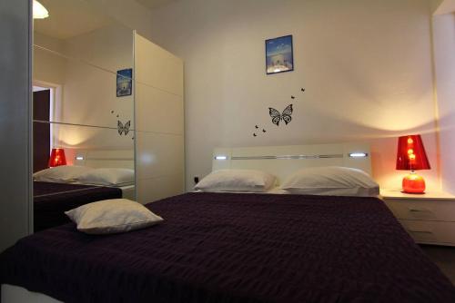 Apartments Cervelin في لوبود: غرفة نوم بسريرين مع وجود فراشات على الحائط