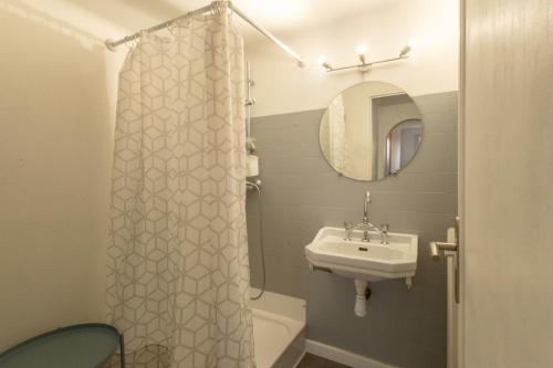 une salle de bain avec un rideau de douche et un lavabo dans l'établissement Le Duplex des Terrasses, à Marseille