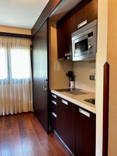 a kitchen with a sink and a microwave at Apartamentos Rurales L'Arquera in Llanes