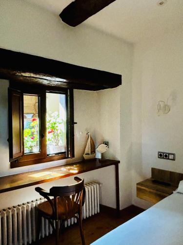 a bedroom with a bed and a table and a window at Apartamentos Rurales L'Arquera in Llanes