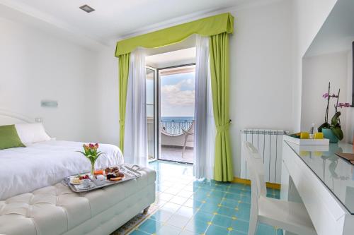 a bedroom with a bed and a view of the ocean at Hotel La Madonnina in Ischia