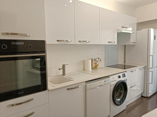 una cucina bianca con lavandino e lavatrice di Juan-Les-Pins centre a Antibes