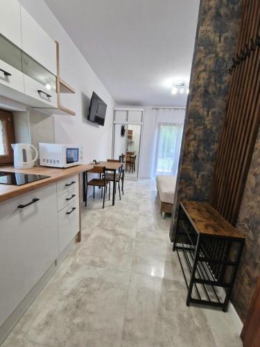 eine Küche und ein Wohnzimmer mit einem Tisch und Stühlen in der Unterkunft Apartament 10 z ogrodem in Szklarska Poręba
