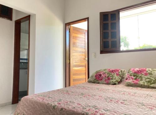 um quarto com uma cama com duas almofadas e uma janela em Villa Nevada Hostel em Bananeiras