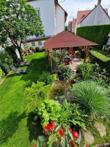 a garden with a gazebo and flowers at Hajnalka vendégház in Bük