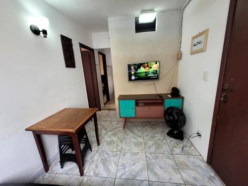 a room with a table and a tv on a wall at AP Econômico do Kilo in Cabo Frio