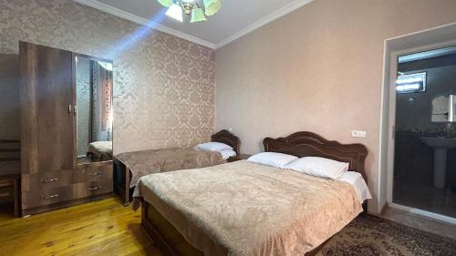 a hotel room with two beds and a mirror at Guest House Maria in Sighnaghi