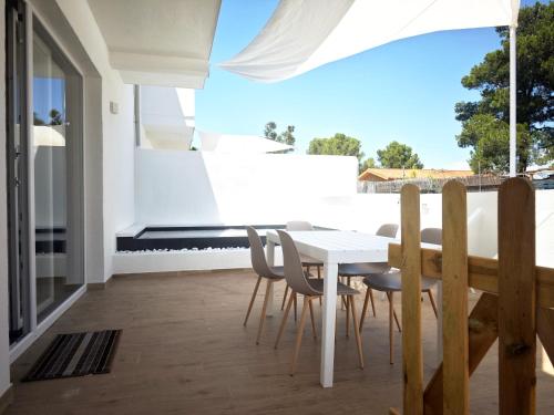 a white table and chairs on a balcony at Suite IKEBANA Porto Pino in Porto Pino