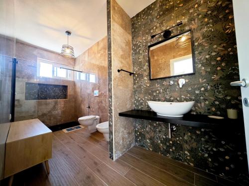 a bathroom with a sink and a toilet at Suite IKEBANA Porto Pino in Porto Pino