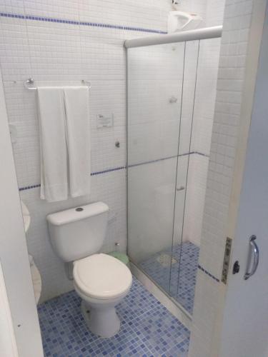 a bathroom with a toilet and a glass shower at LM Suítes in Búzios
