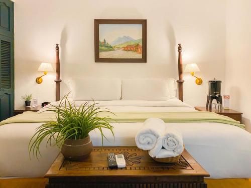 ein Schlafzimmer mit einem Bett und Handtüchern auf dem Tisch in der Unterkunft El Carmen Hotel in Antigua Guatemala