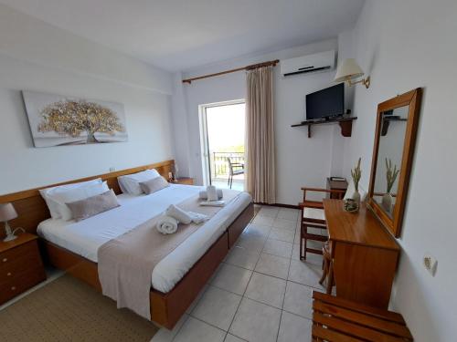 1 dormitorio con 1 cama grande y TV en 75 Steps Apartments, en Mesongi