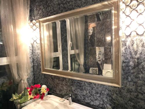 a bathroom with a mirror and a sink at فيلا فندقية بحديقه داخل كمبواند ويستاون بيفرلي هيلز الشيخ زايد بسعر مميز in Sheikh Zayed