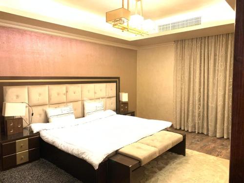 a bedroom with a large bed in a room at فيلا فندقية بحديقه داخل كمبواند ويستاون بيفرلي هيلز الشيخ زايد بسعر مميز in Sheikh Zayed