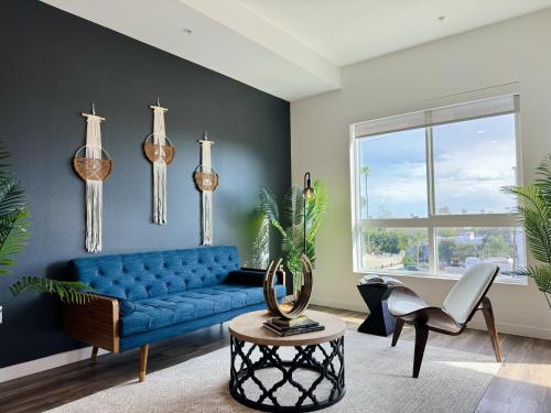 a living room with a blue couch and a window at Modern Hollywood Home Sunset View & Free Parking - 10mins to Universal Studios in Los Angeles