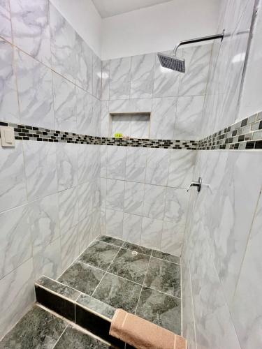 a bathroom with a shower with a tiled floor at Suite Frente al Mar in Puerto Villamil
