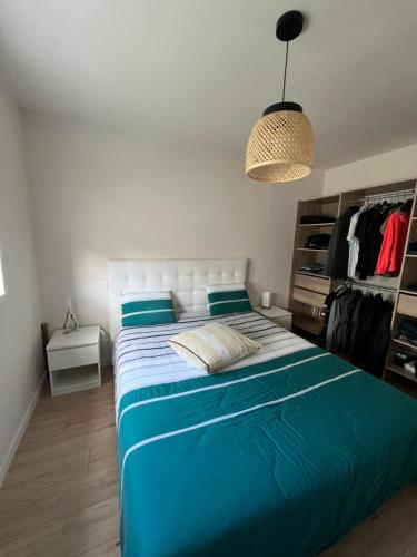 une chambre avec un grand lit avec des draps bleus dans l'établissement Le coteau du verger, à Sulniac