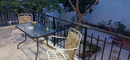 uma mesa e cadeiras sentadas numa varanda em D & X Home em Atenas