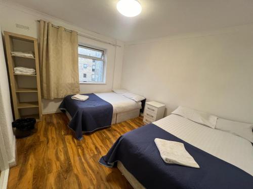 Cette petite chambre comprend 2 lits et une fenêtre. dans l'établissement Maida Vale Urban Living, à Londres
