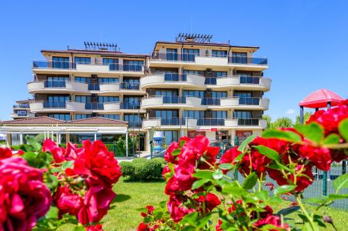 a hotel with red roses in front of a building at Infinity view 2 Shkorpilovci in Shkorpilovtsi