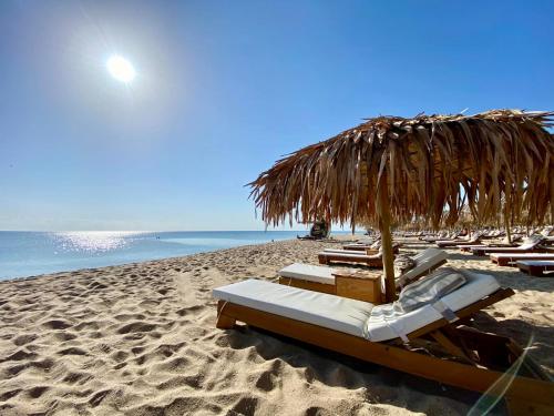 a group of lounge chairs and an umbrella on a beach at Infinity view 2 Shkorpilovci in Shkorpilovtsi