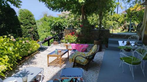 een patio met stoelen, een tafel en planten bij Stomio 4 Seasons Relaxing Apartment in Stómion