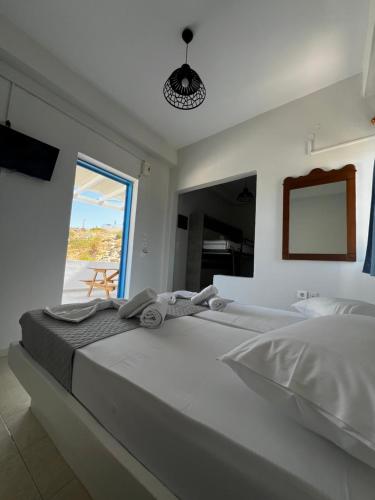 a white bedroom with a large bed and a window at Princess Sissy in Ios Chora