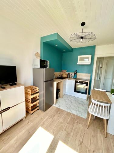 - une cuisine avec un réfrigérateur et une table dans la chambre dans l'établissement Charmant 2 chambres 2 salles de bain, à Besançon