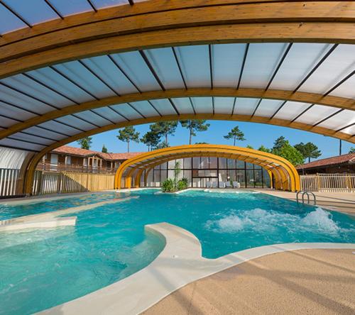 einen großen Pool mit Holzdecke in der Unterkunft Cottage prenium tout confort in Parentis-en-Born