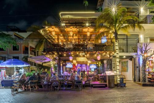 un grupo de personas sentadas en un restaurante por la noche en Hotel Banana Boutique & Spa by Paradise Hotels - 5th Av Playa del Carmen, en Playa del Carmen