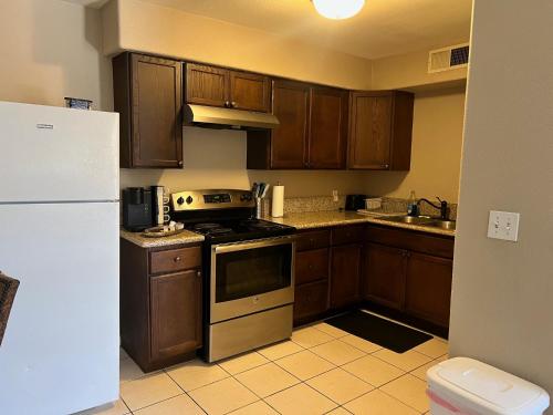 a kitchen with wooden cabinets and a white refrigerator at Serene 2bed 1bath condo with parking in Fresno
