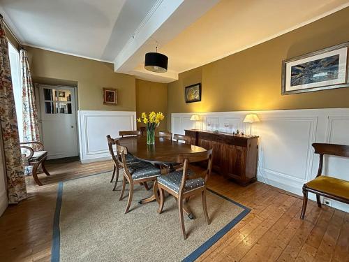 une salle à manger avec une table et des chaises en bois dans l'établissement Belle maison de famille, à Cherbourg en Cotentin