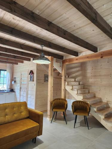 a living room with a couch and two chairs at Ostoja Wigierski in Mikolajewo