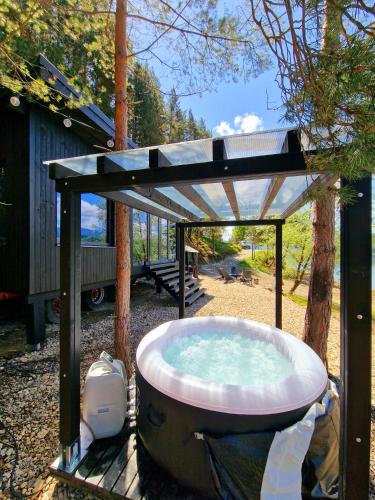 a hot tub with a roof on top of it at Nomad Lake Cabins in Rugineşti