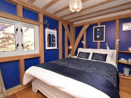 a bedroom with a bed with blue walls and a chandelier at 1 Bed in Biggar 75414 in Biggar