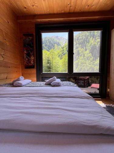 a large bed in a room with a large window at Ayder Paradise Otel in Ayder Yaylasi
