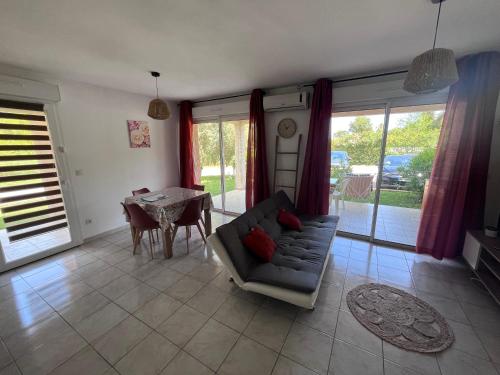 un salon avec un canapé et une table dans l'établissement Studio résidence les Villas de Melody, à Moriani-Plage