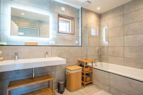 FresnesにあるGreenWoods Ecolodge - Zoo de Beauval et Châteaux de la Loireの洗面台、浴槽、鏡のあるバスルーム