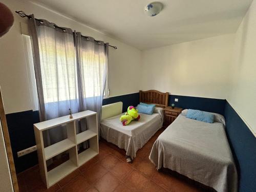 1 dormitorio con 2 camas y un animal de peluche en la cama en Casa en sierra de gredos piscina privada, en La Adrada