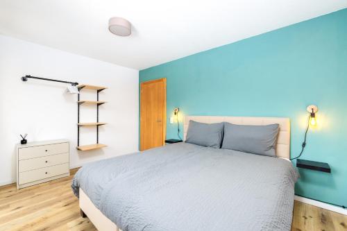 a bedroom with a bed and a blue wall at Jägerlodge Apartments in Ladis