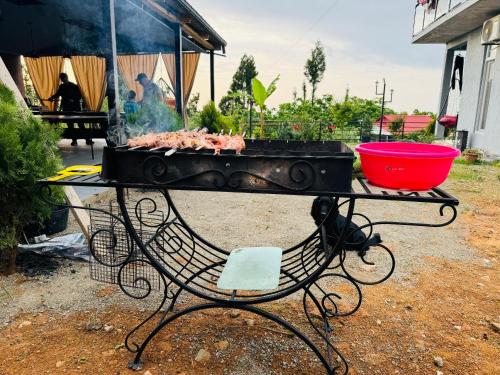 a grill with meat on it on a table at Family Hotel Sunset in Chakvi