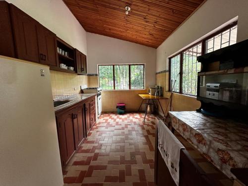 a kitchen with wooden cabinets and a tile floor at Finca Bendita Caña in Villeta