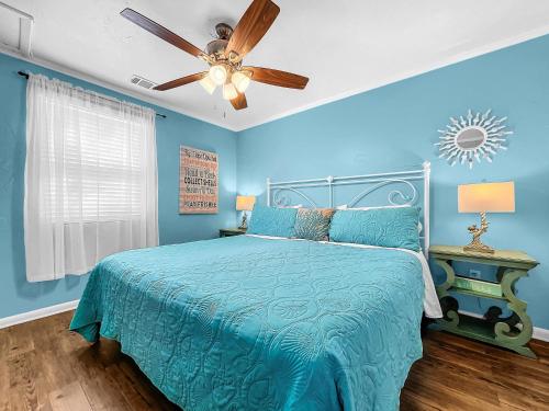 a blue bedroom with a bed and a ceiling fan at Island Hideaway steps to beach dock Bridge St in Bradenton Beach